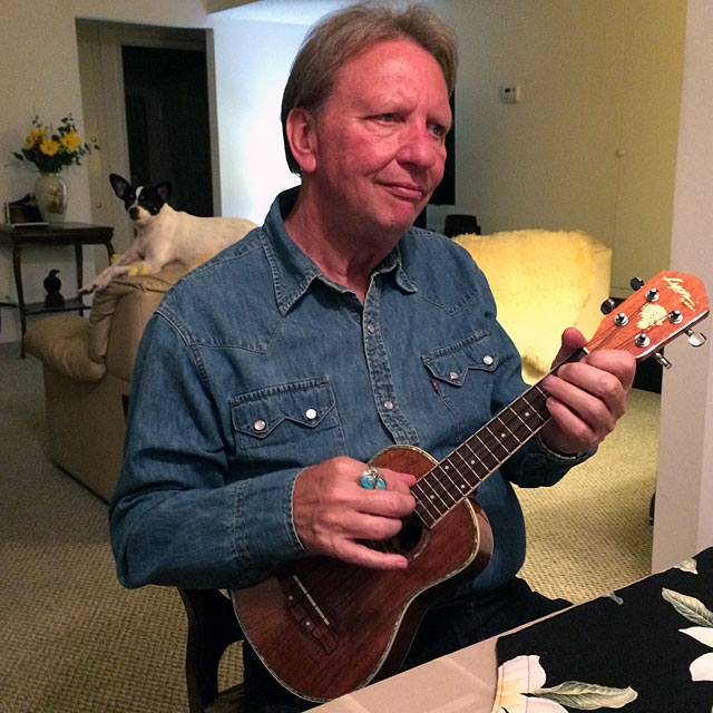 Ken Kinley, showing us how to play ukelele while his dog watches.